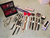 Wide view of the entire lot showing all watches laid out along with the musical jewelry box, small clock, and jewelry cleaning supplies