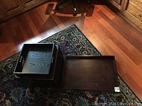 Photo showing the ottoman with the flip-top opened and the additional rectangular serving tray placed next to it on a patterned rug