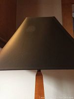 Closeup of the black fabric shade showing its smooth texture and slightly tapered shape.