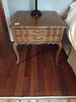 Front view of the Coombe solid wood side table showing two drawers with ornate brass handles, scalloped apron, and cabriole legs.