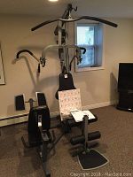 Full view of the Precor Zuma weight training fitness station showing the seated and leg press areas with pulley bars and multiple handles.