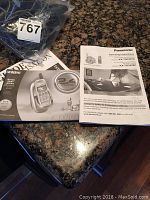 Two bags containing multiple phones and phone manuals visible on countertop.