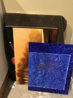 Grouped view of five floral themed art pieces, two identified as photo transfers on board including one with prominent blue floral design and others with warm color palettes.