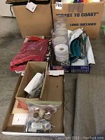 Overview of boxes with craft supplies and fabric pieces with pillows visible