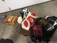 Overview of all bags, purses, duffle bag, and boxes on floor against a wall