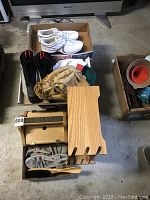Overview of all items arranged in boxes and on floor including Nike shoes, baseball glove, Thinsulate gloves, shoe brush, shoe rack, and other accessories.