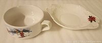 Photo of Christmas-themed ceramic soup bowl and matching decorative dish showing design details.