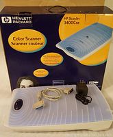 Photo showing HP ScanJet 3400Cse scanner with original box, cables and power adapter.