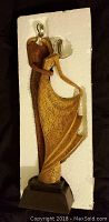 Modern stylized dancing couple figurine in gold and brown tones in protective foam