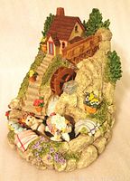 Full view of resin decorative waterwheel figurine depicting cottage on hill with animals and flowers.