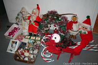 Full view of assorted Christmas decorations including three Santa figures, wreath, candy canes, ornaments, ribbon, and lights
