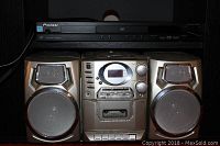 Front view of metallic silver CD and cassette player system with dual speakers and control knobs, plus black Pioneer DVD player on top.