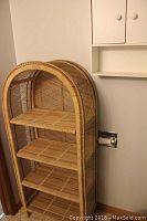 Wicker 4-shelf shelving unit with rounded arched top in tan wicker material.