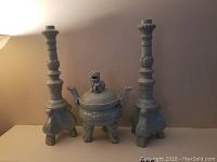 Full set showing one incense holder and two matching candlesticks on each side, ceramic and pale glaze.