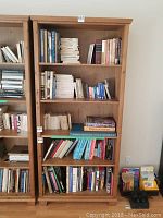 Full front view of the solid pine bookshelf filled with many assorted books showing the size and style of the piece.