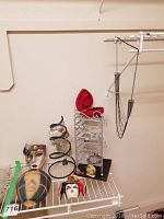 Overall view of jewelry assortment including stands, decorative masks, and jewelry boxes arranged on a white shelf.