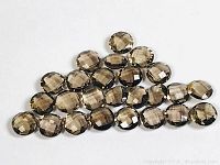 25 dark brown round citrine gemstones arranged on a white surface, showing checkerboard faceted cuts and uniform size.