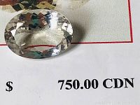 Close-up photo of oval mixed cut Morganite gemstone placed on paper showing appraisal value $750 CAD.