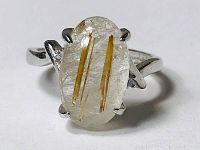 Front close-up showing rutilated quartz gemstone set in a four-prong sterling silver adjustable band.