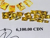 Yellow sapphire stones arranged on printed appraisal showing CDN $6,100 value