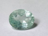 Clear close-up photo of the oval light blue aquamarine showing surface facets and internal characteristics.