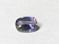 Close-up photo of the purple citrine gemstone showing its cushion oval step cut and clarity from a top angled view.