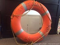 Front view showing the orange lifesaver with reflective bands and central mirror.