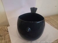 Front view of the charcoal gray finch bird ceramic planter showing the round body, beak detail, and open top.