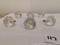 Front view showing six clear glass knobs with faceted design