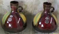 Pair of Mid Century Modern Meran Hohr West Germany pottery vases showing front with color glaze and original labels visible.