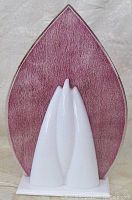 Front view showing the white sculptural base and pink textured acrylic panel shaped like a pointed leaf.