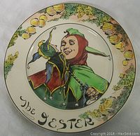 Full view of the plate showing jester illustration and lantern border with inscription