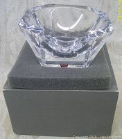 Crystal Orrefors Odyssey bowl shown sitting on gray foam padding inside original gray presentation box. Clear faceted design with Orrefors label visible.