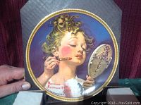 Front view of the Norman Rockwell collector plate featuring a child applying makeup while looking at a hand mirror, titled "Making Believe at the Mirror" with gold trim around the edge.