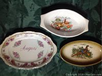 Photo of three ceramic serving platters with decorative designs placed on a green fabric background.