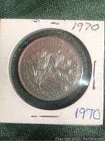 Obverse side of 1970 Canadian silver dollar coin showing Manitoba floral emblem and inscriptions