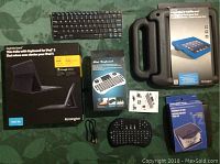 Entire lot overview showing thin folio keyboard case, mini keyboard, Bluetooth keyboard, CD storage box, and iPad cover package.