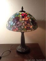 Photo of the lamp fully assembled, showing stained glass floral shade and cord.