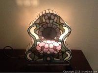 Front view of Tiffany style stained glass mantle clock with floral pattern and Roman numeral clock face.