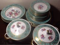 Overview of stacked plates and two covered casseroles showing design and quantity