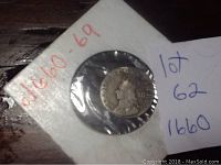 Coin front showing King Charles III profile with inscriptions within a protective sleeve.