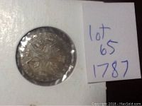 Coin front side showing heraldic design with laurel leaves dated 1787 in protective holder.