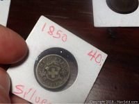 Photo showing the obverse side of the 1850 Swiss 20 Rappen silver coin with Swiss cross and floral design.