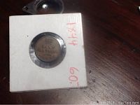 Front view of the half farthing coin dated 1844 displayed in protective holder.