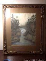 Full view of the framed watercolour painting showing a river landscape with pine trees and rocky banks.