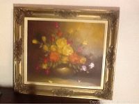 Framed oil painting of a colorful rose bouquet in a vase against a dark background.