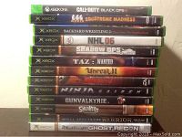 Image showing stacked Xbox and Xbox One game DVDs with visible titles.