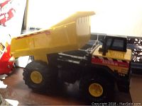 Side view of Tonka Mighty Dump Truck showing yellow dump bed and black cab side with decal