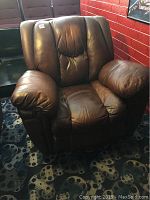 Full view of the brown leather over stuffed recliner chair showing its padded armrests, seat, and backrest.