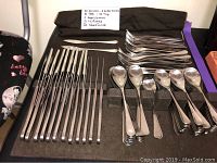 Flatware pieces laid out in original case with handwritten inventory note including 20 knives, 2 butter knives, 20 table spoons, 40 tea spoons, 2 sugar spoons, 15 large forks, 20 small forks.